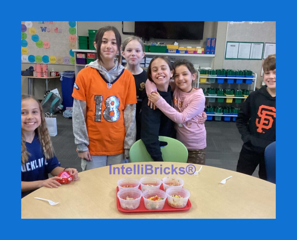 A group of happy students posing together during an IntelliBricks hands-on STEM and healthy cooking workshop