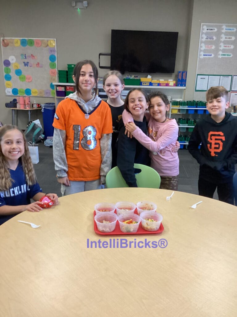 A group of six smiling students posing with their completed mug pizza projects at a STEM summer camp.